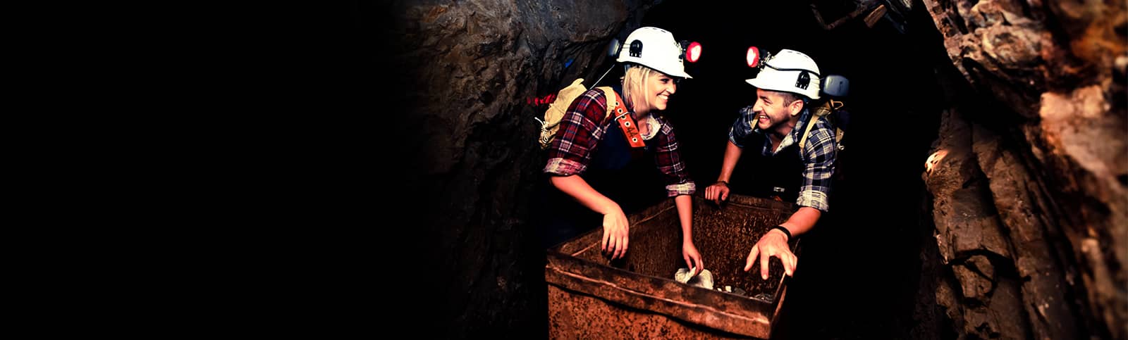 Visitors pushing an Ore Truck on a Nine Levels of Darkness Tour